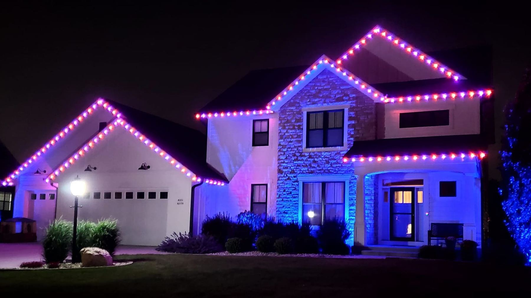 A Bright Beam Co. home lit up at night with red and purple permanent LED lighting