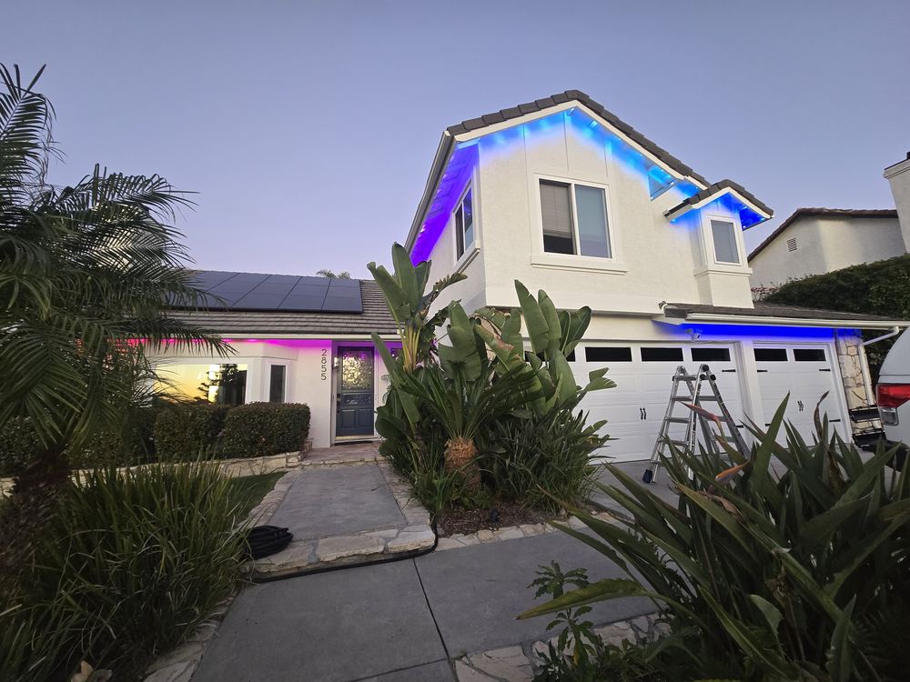 Home with permanent LED lighting glowing purple and blue along the roofline at dusk